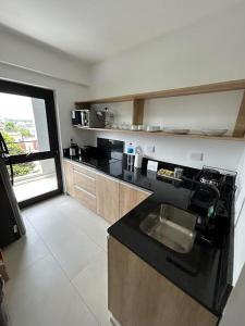 a kitchen with a black counter and a sink at MorenoPLAZA in Concepción del Uruguay