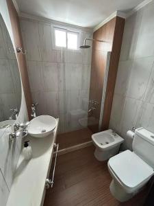 a bathroom with a toilet and a sink and a shower at MorenoPLAZA in Concepción del Uruguay