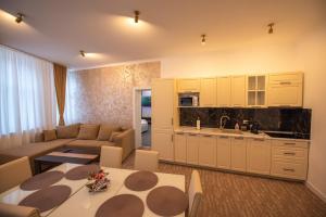 a kitchen and living room with a couch and a table at Vibe 90 Old Town Apartment Craiova in Craiova