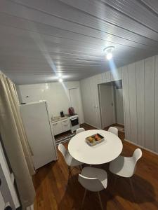 a room with a table and chairs and a refrigerator at Casa Átrio em Biguaçu próximo às Praias in Biguaçu