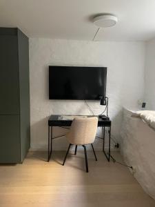 een bureau met een stoel en een televisie aan de muur bij Tranquility near everything - Majorstua in Oslo