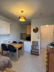 a kitchen and dining room with a table and chairs at SeaNest Le Nid Marin in Saint-Raphaël