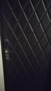 a black door with a metal handle in a room at V by Viaggio in Yerevan