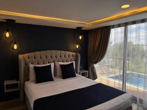 a bedroom with a large bed and a large window at majestic tiny home with private pool in Trikomo +21 photos
