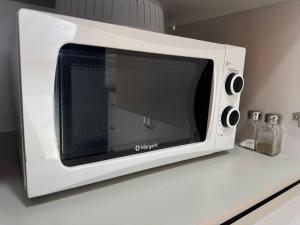 a white microwave oven sitting on a kitchen counter at majestic tiny home with private pool in Trikomo