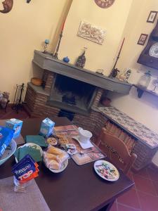 una mesa con platos de comida y una chimenea en A casa di Mariarosaria, en Pozzovetere