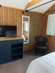 a bedroom with a bed and a desk and a chair at Sleeping Bear Riverside Cabins in Honor