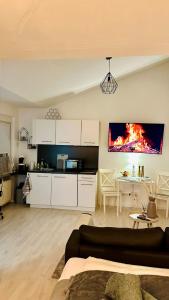a kitchen and a living room with a fire on the wall at Charmante Ferienwohnung im Herzen von Winningen in Winningen