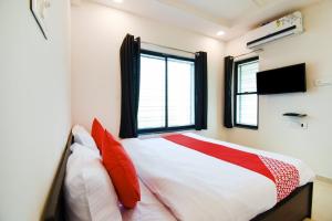 a bedroom with a bed with red pillows and a window at Collection O White House Regency in Nagpur