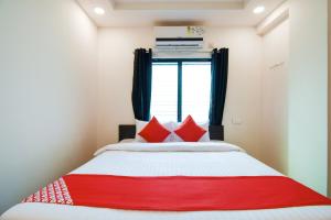 Un dormitorio con una cama roja y blanca y una ventana en Super Collection O White House Regency, en Nagpur 28 fotos más