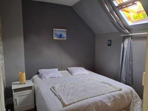 费康Les Petits Galets的一间卧室，里面有一张白色床，窗外是一扇窗户。 更多8张照片