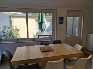 费康Les Petits Galets的用餐室配有桌椅和遮阳伞