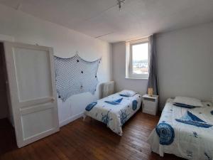 费康Les Petits Galets的有两张床和一扇窗户的卧室