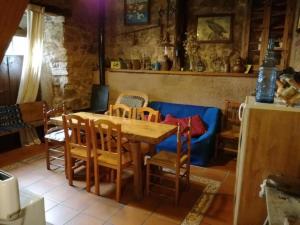 ein Esszimmer mit einem Tisch und einem blauen Sofa in der Unterkunft Casa Lucia in Mogarraz + 20 Fotos