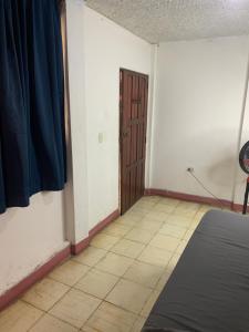 une chambre avec un lit, une porte et un sol carrelé dans l'établissement Habitación Privada Casa Privada, à Granada