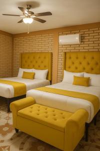 ein Schlafzimmer mit zwei Betten und einer Couch darin in der Unterkunft Hotel Flamora in Francisco Zarco