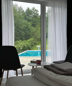a living room with a view of a pool through a window at Vila Amore Sarajevo Bjelasnica  +5 photos