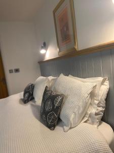 a bed with four pillows on top of it at Rhubarb Barn bedroom only in Diss