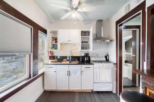 una cucina con armadi bianchi e un ventilatore a soffitto di The City Climb a Guttenberg