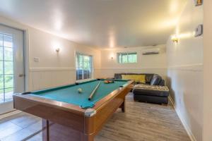 Una sala de estar con una mesa de billar y un sofá. en Lake Views, Hot Tub, Fireplace and Pool Table, en Chertsey