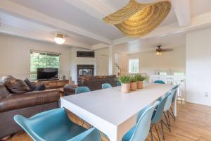 sala de estar con mesa blanca y sillas azules en Lake Views, Hot Tub, Fireplace and Pool Table, en Chertsey