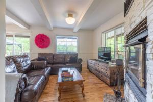 Una sala de estar con un sofá de cuero y una chimenea. en Lake Views, Hot Tub, Fireplace and Pool Table, en Chertsey