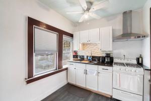una cucina con armadi bianchi e un ventilatore a soffitto di The City Climb a Guttenberg Altre 15 foto