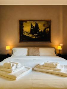 a bedroom with a large white bed with towels on it at Ales apartment in Cuneo