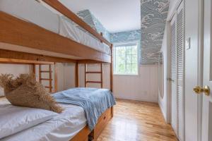 Un dormitorio con dos literas y una ventana. en Lake Views, Hot Tub, Fireplace and Pool Table, en Chertsey