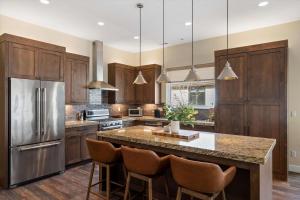 eine Küche mit Holzschränken und eine große Insel mit Barstühlen in der Unterkunft Trappers Ridge Home Stunning Mountain Views and Family Fun in Wolf Creek Village + 43 Fotos