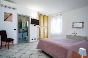 伊斯基亚Casa Don Peppino City Center的一间卧室，配有一张床、一把椅子和一台电视机