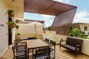 un patio con tavolo e sedie in legno e un ombrellone di New! Gorgeous Tulum luxury villa with 2 pools a Tulum