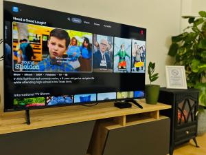 a flat screen tv sitting on top of a wooden table at Black and Ginger Residence in Zrenjanin
