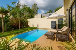 una piscina con una sedia e un ombrellone di New! Gorgeous Tulum luxury villa with 2 pools a Tulum