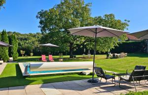 圣提里耶拉佩尔什L'Horizon - Domaine du Vertendre的一个带两把椅子和一把遮阳伞的游泳池