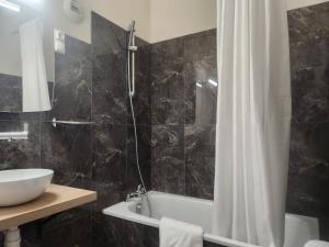 ein Badezimmer mit Badewanne, Waschbecken und Dusche in der Unterkunft Hôtel et Restaurant Les2M in Fontenay-le-Comte