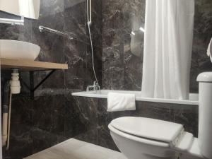a bathroom with a toilet and a sink at Hôtel et Restaurant Les2M in Fontenay-le-Comte