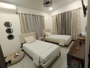 una habitación de hotel con dos camas y una mesa en JJ Lux Residential, en Jacó 2 fotos más