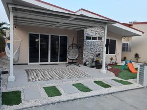 un patio con toldo frente a una casa en JJ Lux Residential, en Jacó