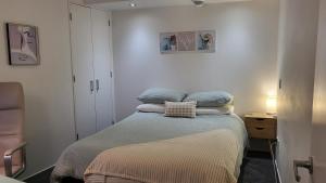 a bedroom with a bed with pillows on it at Stylish Home within Central Wellington - Free Parking in Wellington