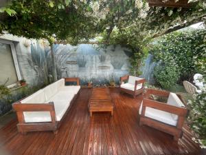 a patio with a white couch and two chairs at Carpediemch in Chascomús