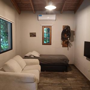 un soggiorno con un divano e un letto di La morita hospedaje a Brandsen