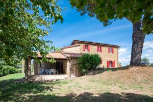 una vista esterna della casa con le finestre rosse di IL MELOGRANO a Scarlino