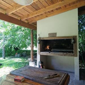 un camino esterno in un patio con soffitto in legno di La morita hospedaje a Brandsen