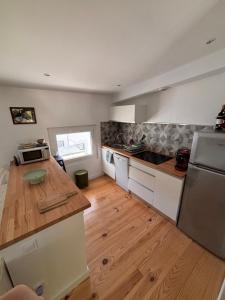 a kitchen with white cabinets and a wooden floor at Superbe T3 lumineux à louer à Bidart, proche océan et centre ville in Bidart