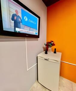 a television on a wall above a refrigerator at #MaReSiaSdaPaz próximo ao centro de Matinhos in Matinhos +3 photos