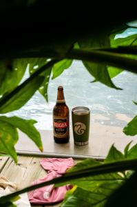 a bottle of beer and a glass on a table at Hotel Michanti in El Zonte