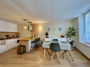 eine Küche und ein Wohnzimmer mit Tisch und Stühlen in der Unterkunft Les Gîtes de l'ile à Metz in Metz