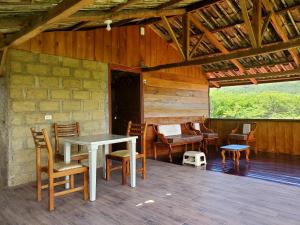 a table and chairs on a porch of a house at Cabaña Mirador de Vilcabamba in Vilcabamba