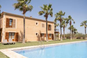 a villa with a swimming pool and palm trees at Agroturismo Son Marge in Campos